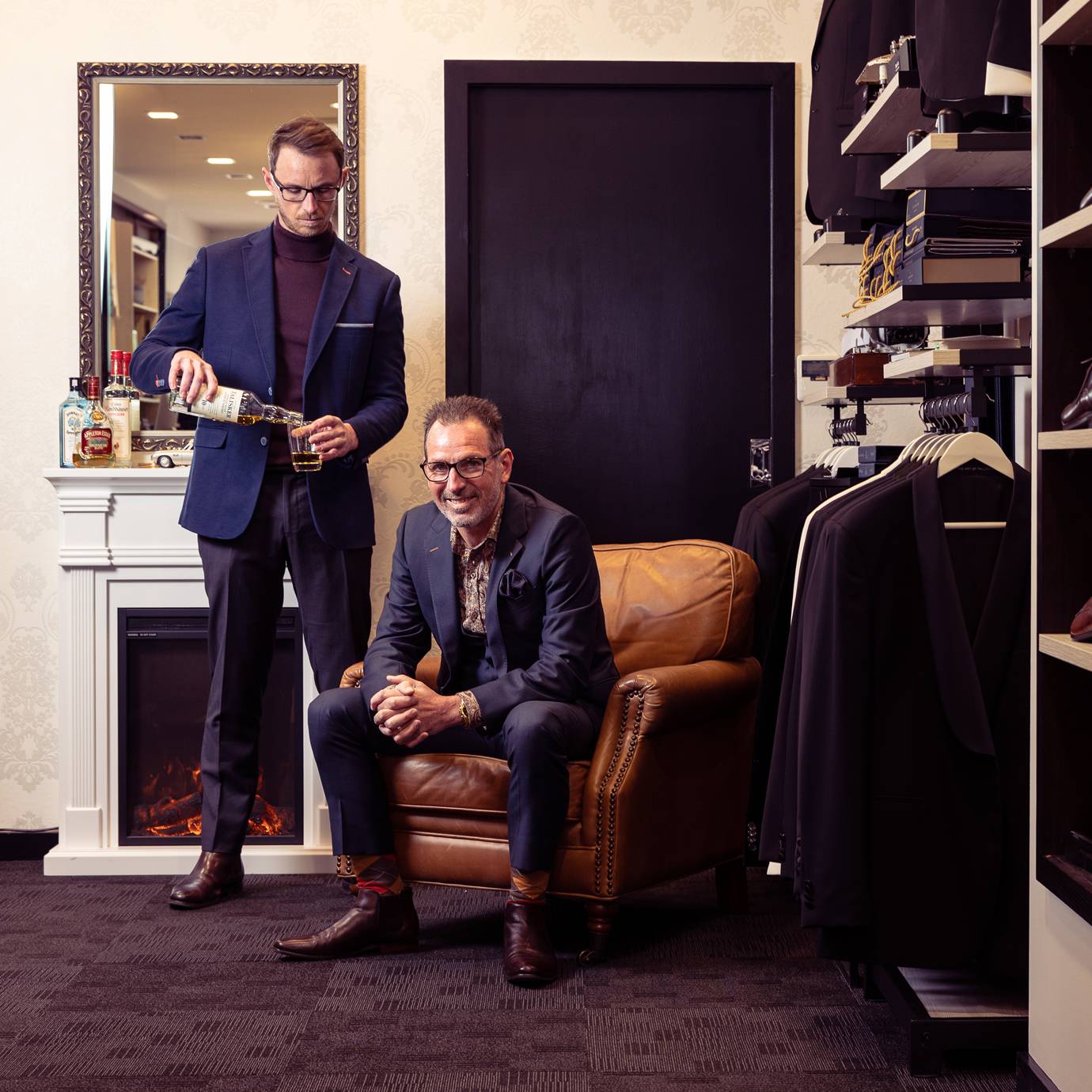 Two Bond & Co tailors sharing a drink together in the fitting lounge